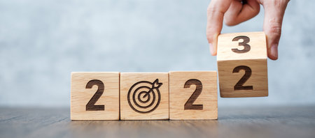 hand flip 2022 to 2023 block with dartboard sign. Business Goal, Target, Resolution, strategy, plan,...