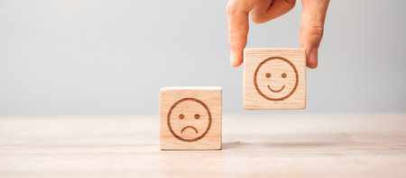 Man hand holding emotion face block. Customer choose Emoticon for user reviews. Service rating,...