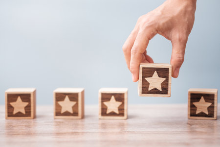Man hand holding Star block. Customer choose rating for user reviews. Service rating, ranking, customer review, satisfaction, evaluation and feedback conceptの写真素材