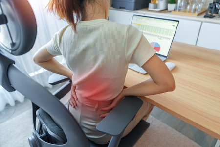 Woman having back body pain during work long time on workplace. due to Piriformis, Low Back, waist ache, lumbago, kidney, rheumatism and Spinal Compression. Office syndrome and Ergonomic conceptの写真素材
