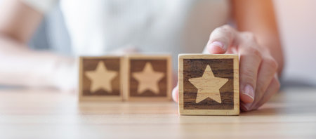 hand holding Star block. Customer choose rating for user reviews. Quality, Service rating, ranking, customer review, satisfaction, evaluation and feedback conceptの写真素材