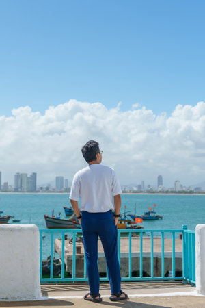 man traveler visiting at Son Tra marina. Tourist with blue dress and hat traveling in Da Nang city....