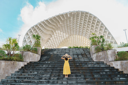 Woman Traveler with yellow dress visiting in Da Nang city. Tourist sightseeing the city building....
