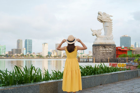 Woman Traveler  visiting in Da Nang. Tourist sightseeing the river view with Carp Dragon Statue or Ca Chep Hoa Rong.Landmark and popular. Da Nang, Vietnam, 13 November 2022のeditorial素材