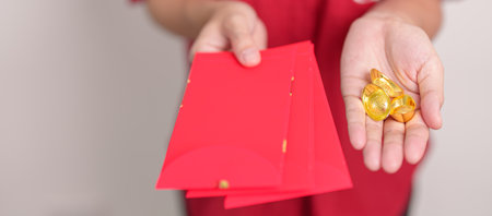 Woman holding Chinese red envelope with gold bullion, money gift for happy Lunar New Year holiday....