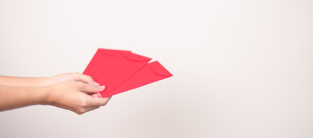 Woman holding Chinese red envelope, money gift for happy Lunar New Year holidayの写真素材
