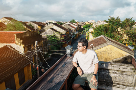 happy traveler traveling at Hoi An ancient town in Vietnam, man sightseeing view at rooftop. landmark and popular for tourist attractions. Vietnam and Southeast Asia travel conceptの写真素材