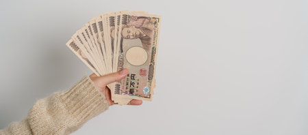 Woman hand holding Japanese Yen banknote stack. Thousand Yen money. Japan cash, Tax, Recession...