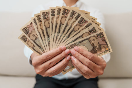 man hand holding Japanese Yen banknote stack. Thousand Yen money. Japan cash, Tax, Recession Economy, Inflation, Investment, finance and shopping payment conceptsの写真素材