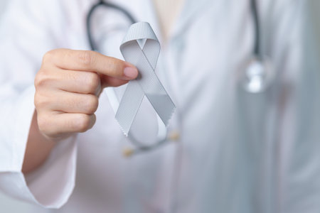 Brain Cancer Awareness May month, Doctor with grey color Ribbon for supporting life people. Healthcare and World cancer day conceptの写真素材