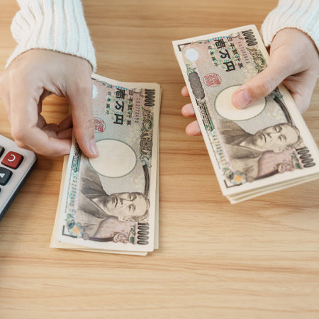 Woman hand counting Japanese Yen banknote with calculator. Thousand Yen money. Japan cash, Tax, Recession Economy, Inflation, Investment, finance, savings, salary and payment conceptsの写真素材