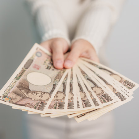 Woman hand holding Japanese Yen banknote stack. Thousand Yen money. Japan cash, Tax, Recession Economy, Inflation, Investment, finance and shopping payment conceptsの素材 [FY310200874609]