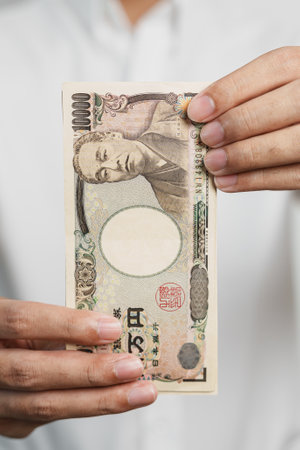 man hand holding Japanese Yen banknote stack. Thousand Yen money. Japan cash, Tax, Recession Economy, Inflation, Investment, finance and shopping payment conceptsの写真素材
