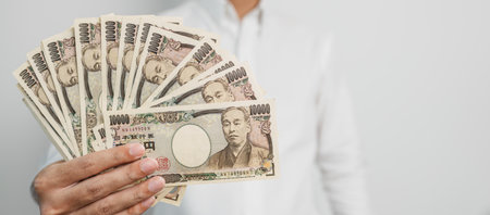 man hand holding Japanese Yen banknote stack. Thousand Yen money. Japan cash, Tax, Recession Economy, Inflation, Investment, finance and shopping payment conceptsの写真素材