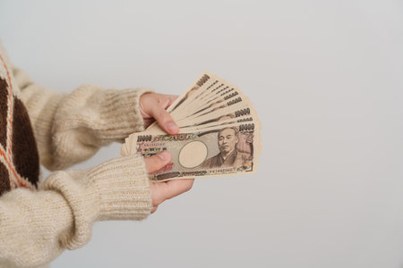 Woman hand holding Japanese Yen banknote stack. Thousand Yen money. Japan cash, Tax, Recession Economy, Inflation, Investment, finance and shopping payment conceptsの写真素材