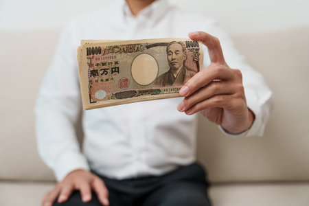 man hand holding Japanese Yen banknote stack. Thousand Yen money. Japan cash, Tax, Recession Economy, Inflation, Investment, finance and shopping payment conceptsの写真素材