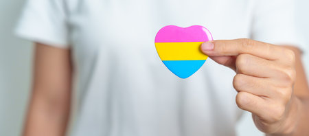 Pansexual Pride Day and LGBT pride month concept. hand holding pink, yellow and blue heart shape for Lesbian, Gay, Bisexual, Transgender, Queer and Pansexual communityの写真素材