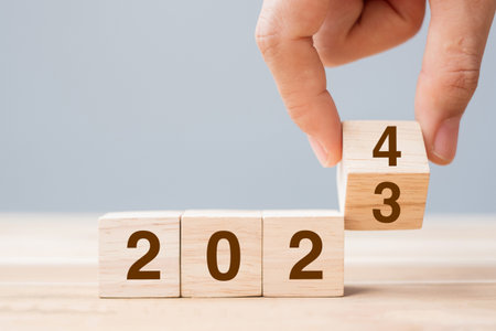 hand flip cube block 2023 to 2024 text on table. Resolution, review, strategy, end year, goal,...