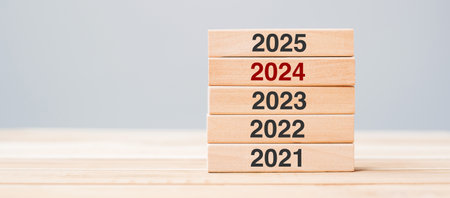2025 block over 2024 and 2023 wooden building on table background. Business planning, Risk Management, Resolution, strategy, solution, goal, New Year New You and happy holiday conceptsの写真素材