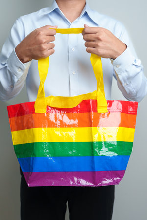 LGBT pride month concept or LGBTQ+ or LGBTQIA+ woman with Eco friendly bag with rainbow colorの写真素材