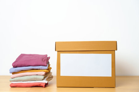 Donation, Charity, Volunteer, Giving, Delivery and Home Moving Concept. Clothes with cardboard box at home or offices for support and help poor, refugee and homeless people. Copy space for textの写真素材