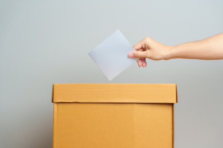 Voting and Democracy concept. Man hand putting ballot in election box, Democracy referendum for government, President and Prime Minister Voteの写真素材