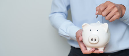 Money Saving for Future Plan, Retirement fund, Pension, Investment, Wealth Business and Financial concepts. hand holding and putting into piggy bank, Money Counting for World Savings day and Donateの写真素材
