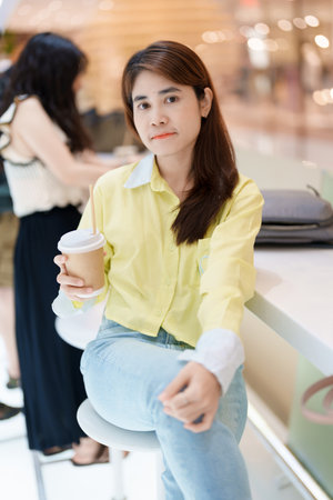 young woman drinking coffee, female hand holding and enjoying a cup of tea at cafe shopの写真素材