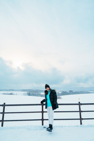 Woman tourist Visiting in Biei, Traveler in Sweater sightseeing view with Snow in winter season. landmark and popular for attractions in Hokkaido, Japan. Travel and Vacation conceptの写真素材