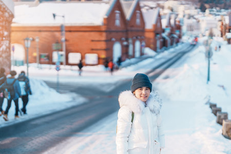 Woman tourist Visiting in Hakodate, Traveler in Sweater sightseeing Kanemori Red Brick Warehouse with Snow in winter. landmark and popular for attractions in Hokkaido,Japan.Travel and Vacation conceptの写真素材