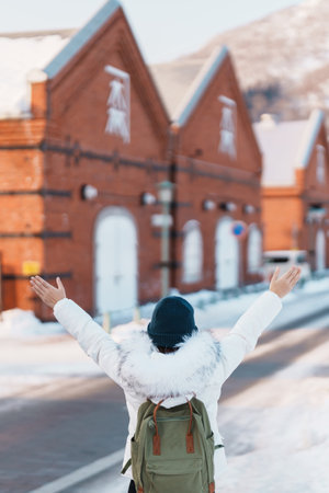 Woman tourist Visiting in Hakodate, Traveler in Sweater sightseeing Kanemori Red Brick Warehouse with Snow in winter. landmark and popular for attractions in Hokkaido,Japan.Travel and Vacation conceptの写真素材