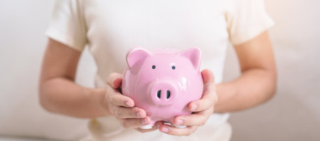 Money Saving for Future Plan, Retirement fund, Pension, Investment, Wealth Business and Financial concepts. hand holding and putting into piggy bank, Money Counting for World Savings day and Donateの写真素材