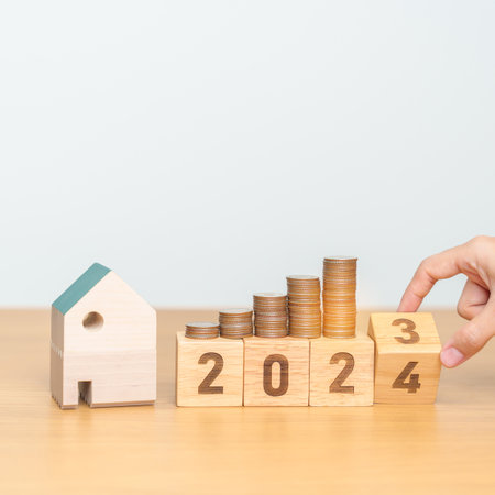2023 flipping to 2024 year block with house model and Coins stack. real estate, Home loan, tax,...
