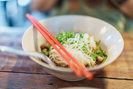 Thai Boat noodle thicken soup with Pork, balls, crispy fried pork skin, basil leaf and Vegetables. Traditional and Famous Street food in Thailandの写真素材