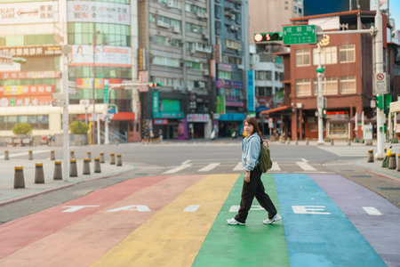 woman traveler visiting in Taiwan, Tourist sightseeing at rainbow crosswalk in ximending, Taipei City. landmark and popular attractions. Taipei, Taiwan, 2023 April 05のeditorial素材