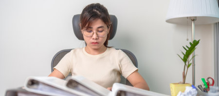 Asian woman having Tired and Stressed while working, female businesswoman having headache and...