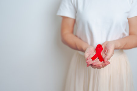 woman with Red Ribbon for December World Aids Day, acquired immune deficiency syndrome, multiple myeloma Cancer Awareness month and National Red ribbon week. Healthcare and world cancer day conceptの写真素材