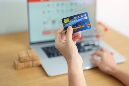woman hand holding credit card and using laptop with mobile phone for online shopping while making order. Marketplace platform website, technology, ecommerce, shipping delivery and online paymentの写真素材