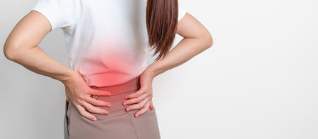 adult female with muscle pain on gray background. Elderly woman having back body ache due to...