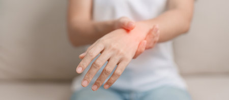 Woman having wrist pain during sitting on sofa at home, muscle ache due to De Quervain s tenosynovitis, ergonomic, Carpal Tunnel Syndrome or Office syndrome conceptの写真素材
