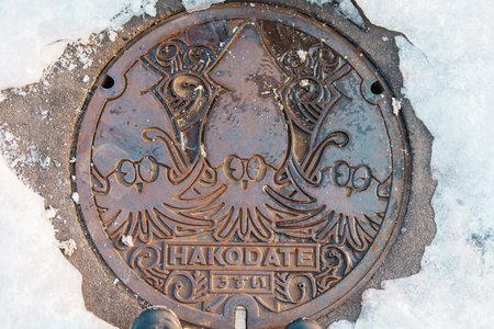 Hakodate city manhole cover with snow in winter season. Hakodate in one of landmark and popular for tourists attractions in Hokkaido, Japan. Travel and Vacation conceptの写真素材
