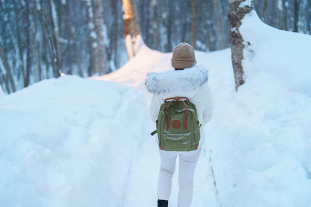 Woman tourist Visiting in Furano, Traveler in Sweater sightseeing Ningle Terrace Cottages with Snow in winter. landmark and popular for attractions in Hokkaido, Japan. Travel and Vacation conceptの写真素材