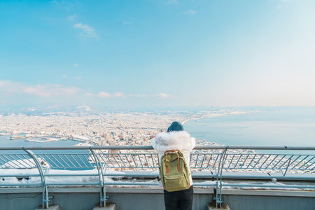 Woman tourist Visiting in Hakodate, Traveler in Sweater sightseeing view from Hakodate mountain with...
