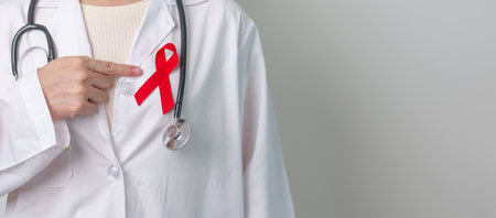Doctor with Red Ribbon for December World Aids Day, acquired immune deficiency syndrome, multiple myeloma Cancer Awareness month and National Red ribbon week. Healthcare and world cancer day conceptの写真素材