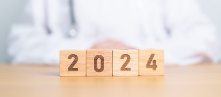 Doctor hand flipping 2023 to 2024 block. Happy New Year for Medical, Health care, Insurance and Wellness conceptsの写真素材