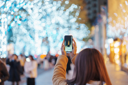 Traveler visiting Roppongi Hills Christmas Illumination and taking photo Tokyo tower, happy tourist woman stands on a christmas market in Tokyo, Japan. Travel, holiday and celebrations conceptの写真素材