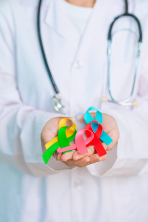 World cancer day, February 4. Doctor hold colorful ribbons, blue, yellow, red, green, white, pink and grey for supporting people living and illness. Health, Medical, awareness and Insurance conceptの写真素材