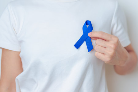 March Colorectal Cancer Awareness month, doctor with dark Blue Ribbon for supporting people living and illness. Healthcare, hope and World cancer day conceptの写真素材