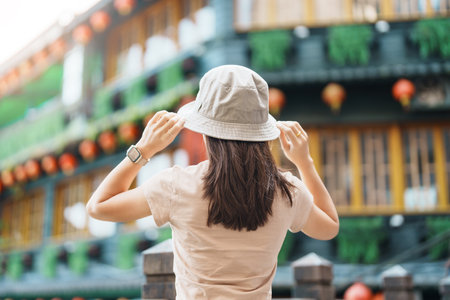 woman traveler visiting in Taiwan, Tourist with hat sightseeing in Jiufen Old Street village with Tea House background. landmark and popular attractions near Taipei city . Travel and Vacation conceptの写真素材