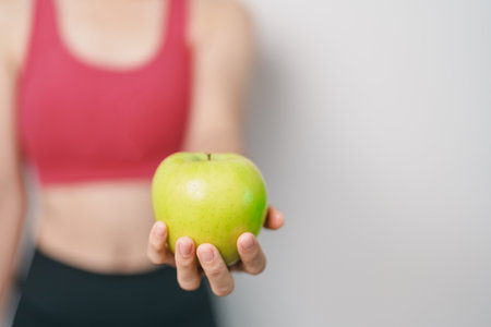 woman hand hold green Apple, happy female fitness choose fruit is Healthy food. Dieting control, Weight loss, Obesity, eating lifestyle and nutrition conceptsの写真素材